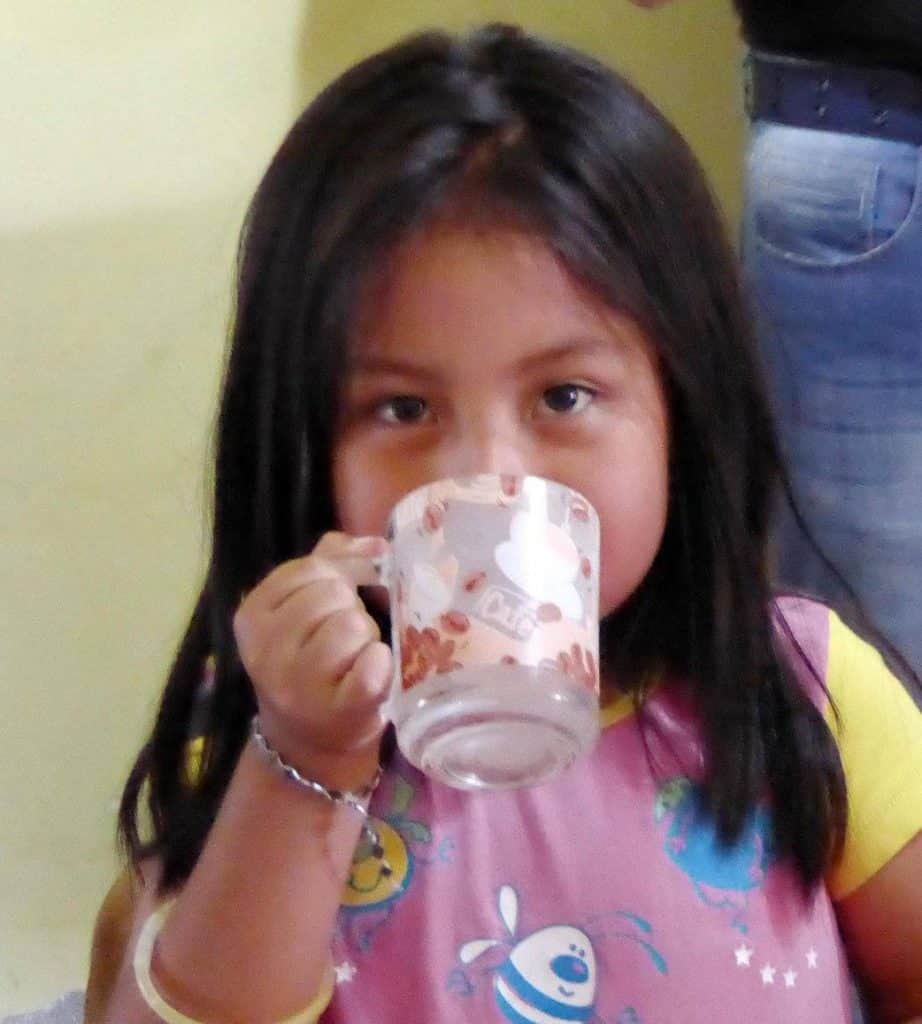Girl drinking clean water in Ecuador provided by Project M:25